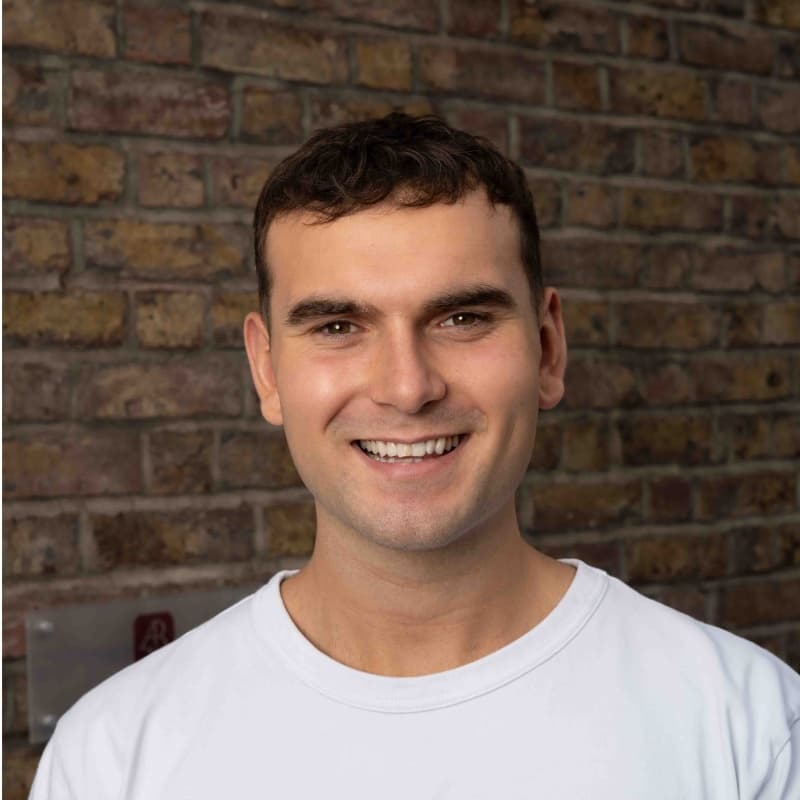 Luke Carroll, photographed against a brick wall.